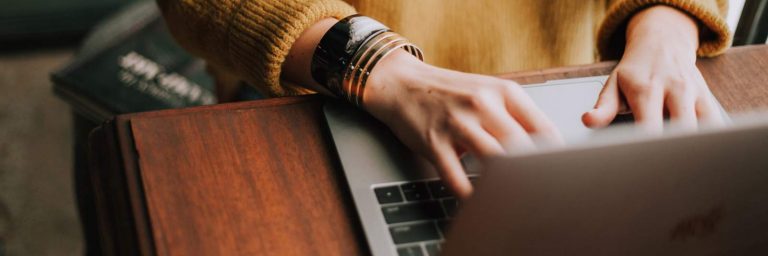Photo of hands typing on a laptop